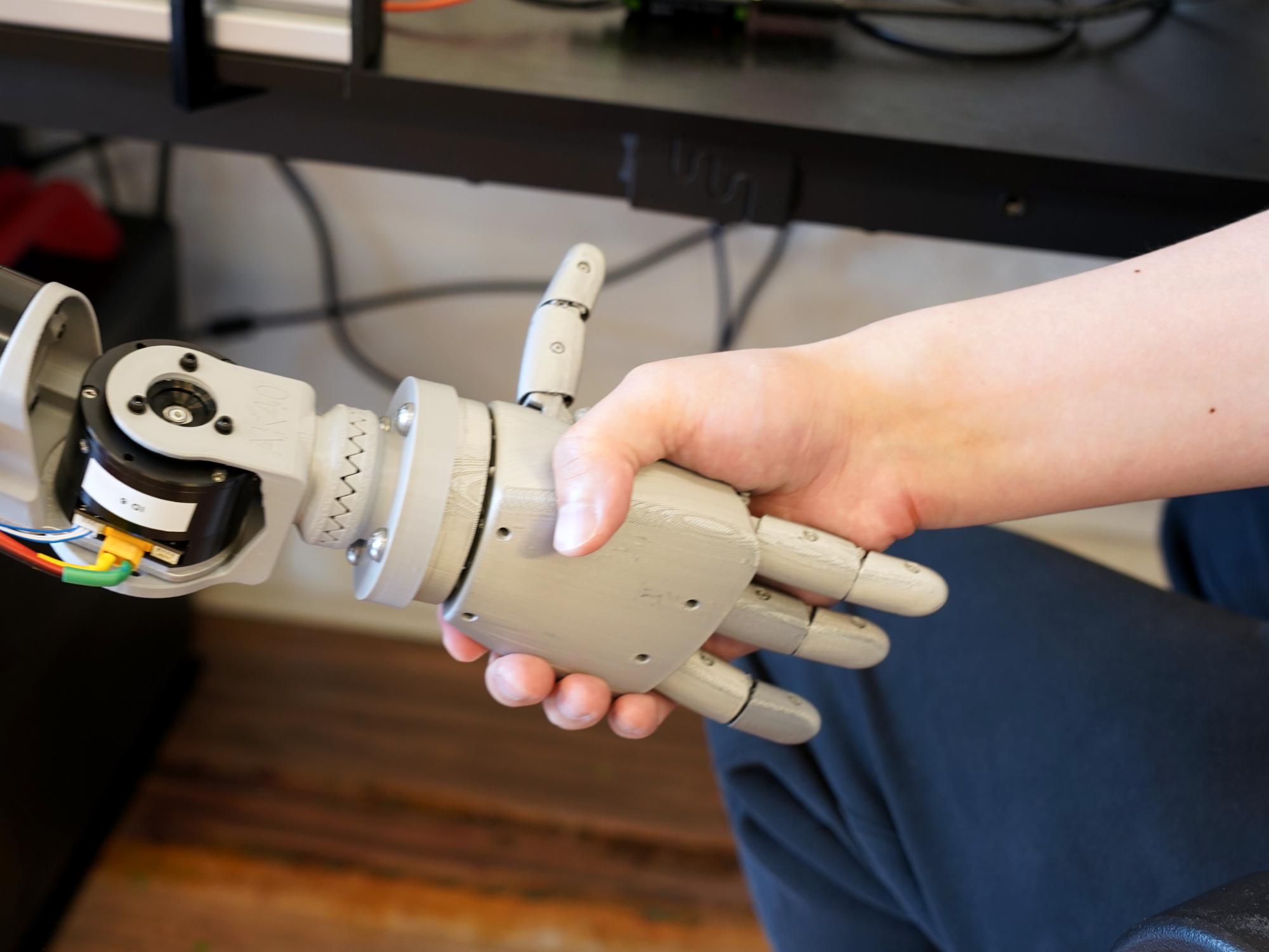 Human hand shaking Codey the robot's hand